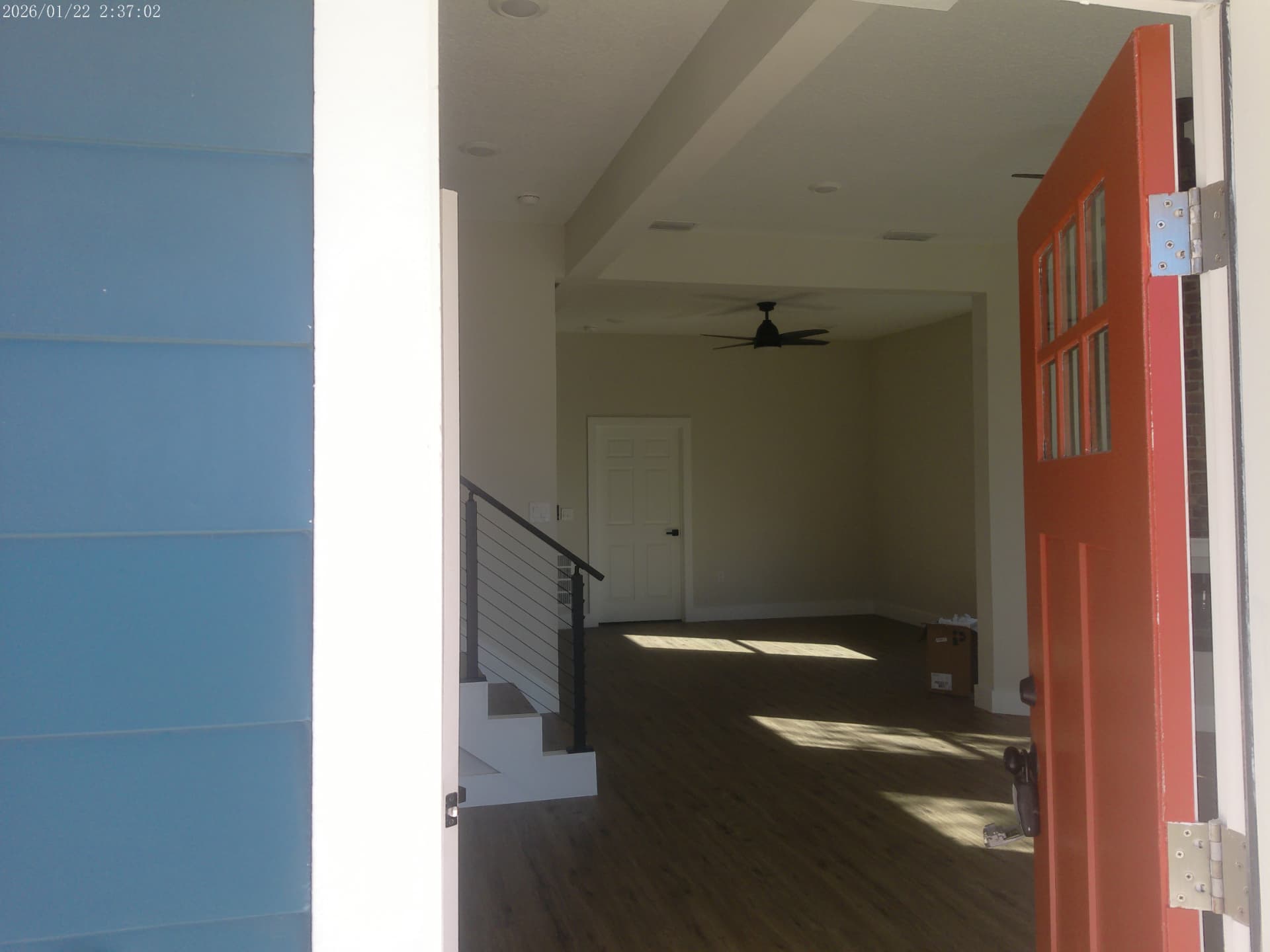 Entry foyer with open stair, cable railing, and dark plank flooring