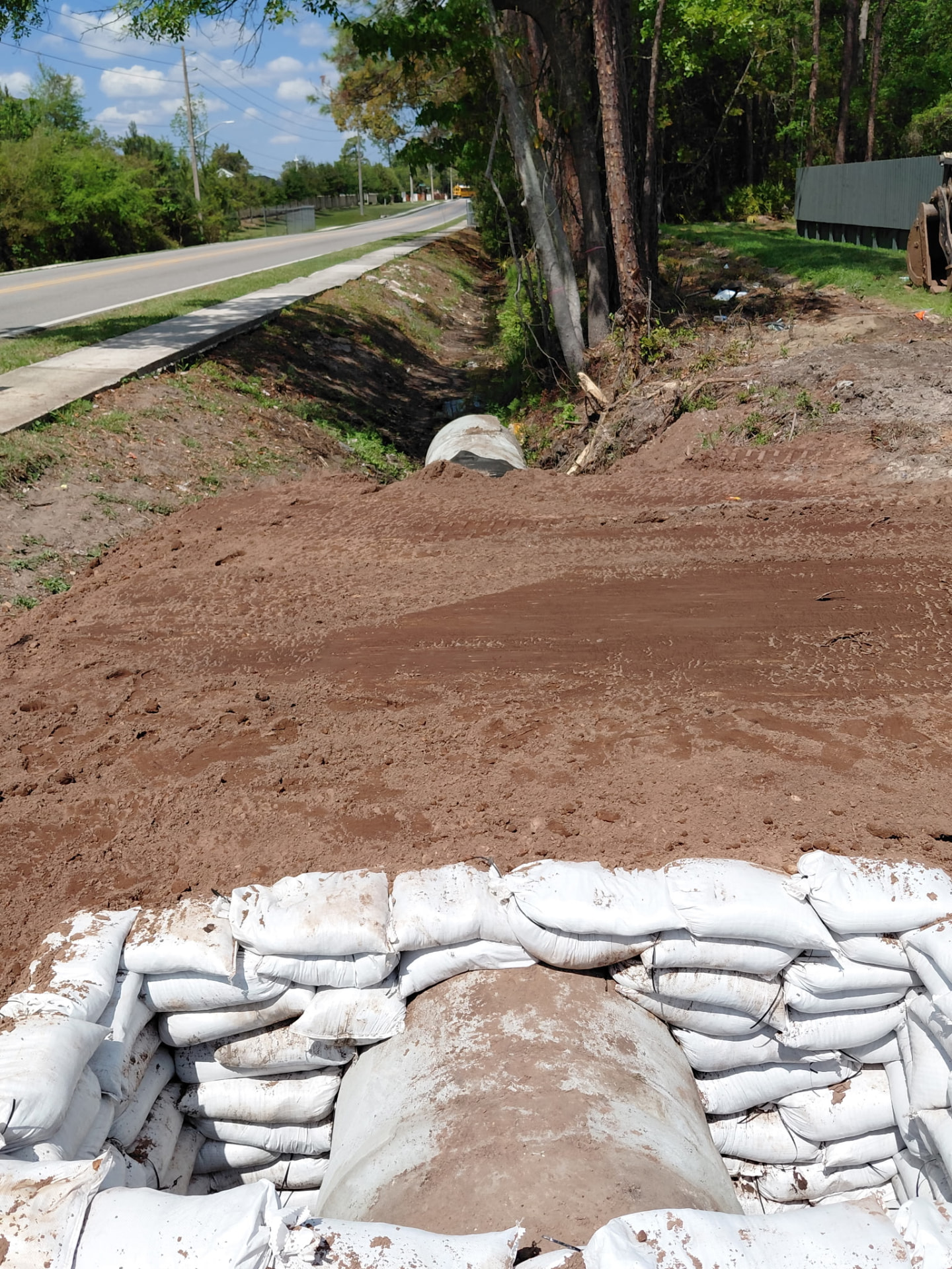 Restored roadside ditch and concrete culvert with sandbag erosion protection