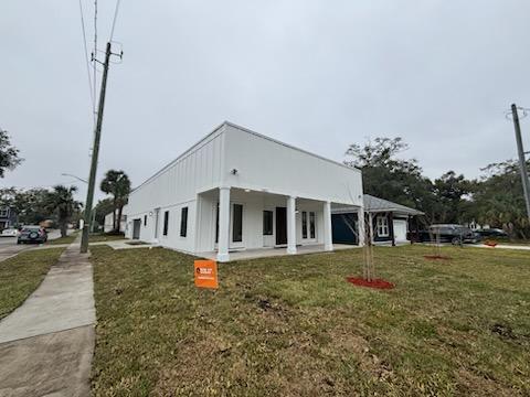 Side elevation of the new Florida Avenue home showing board-and-batten siding and covered porch
