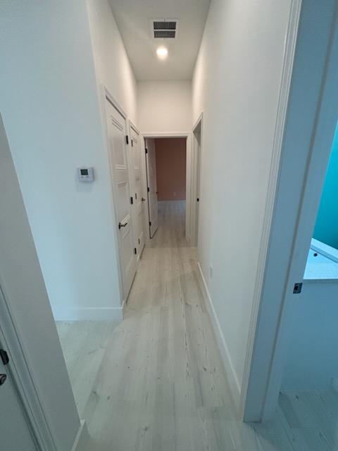 Finished interior hallway with painted trim and wide-plank flooring