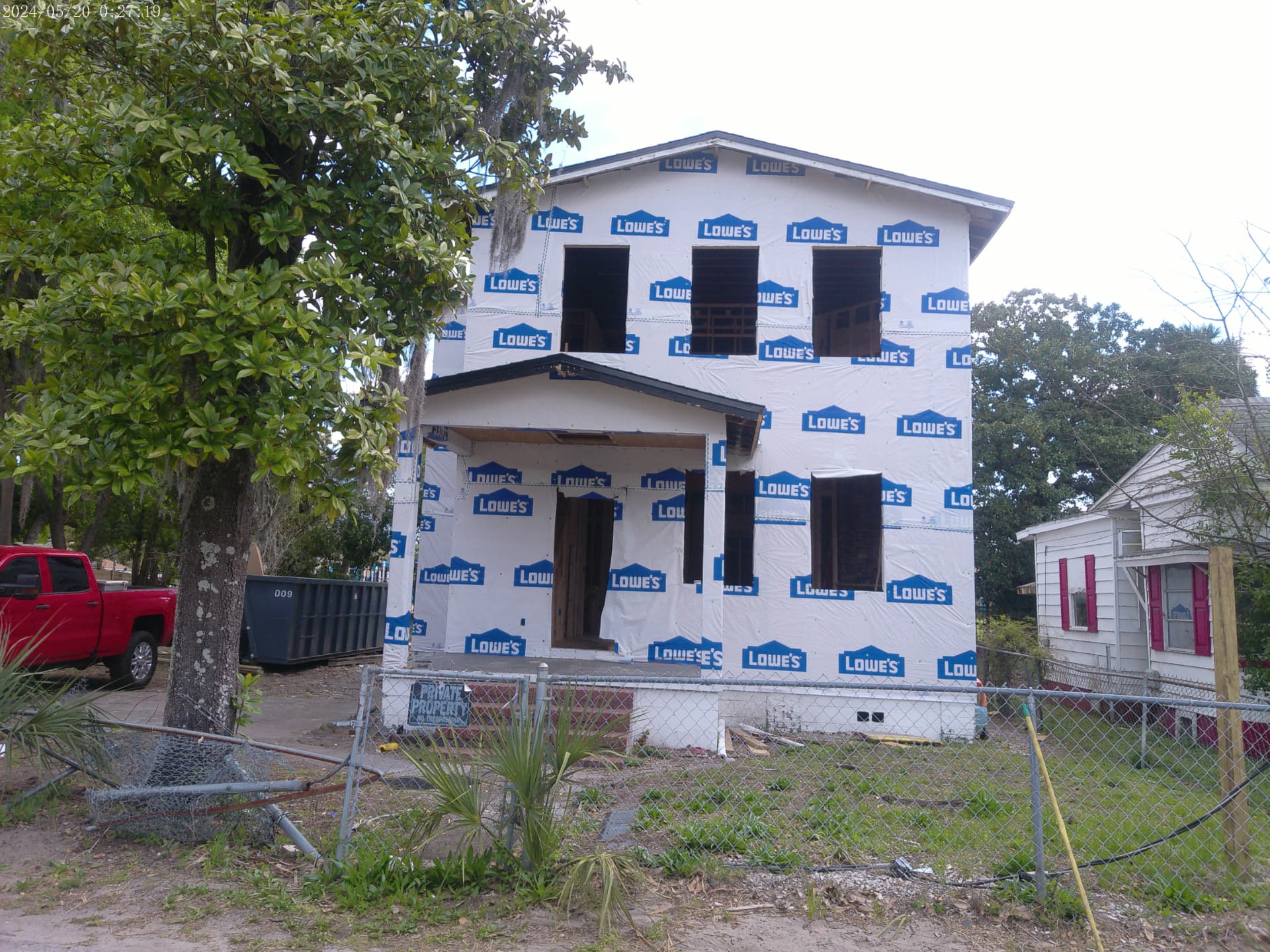 Two-story Spearing Street home under construction with house wrap and open window openings