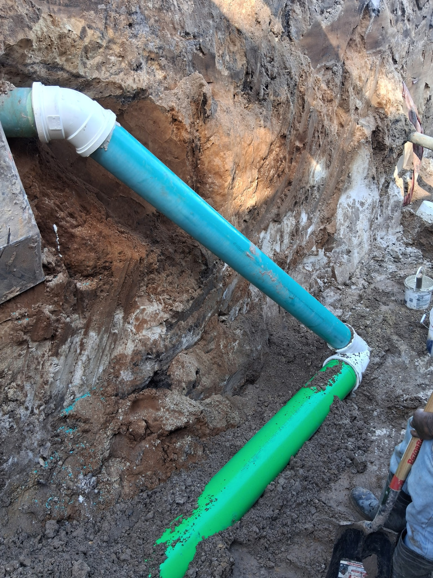New water main and gravity sewer pipe installed in an open trench on Bertha Street